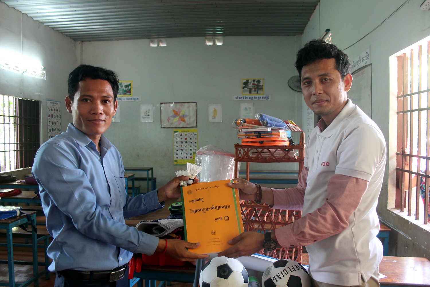 La consegna del materiale scolastico a un insegnante cambogiano