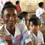 Un padre e un bambino cambogiano aiutati