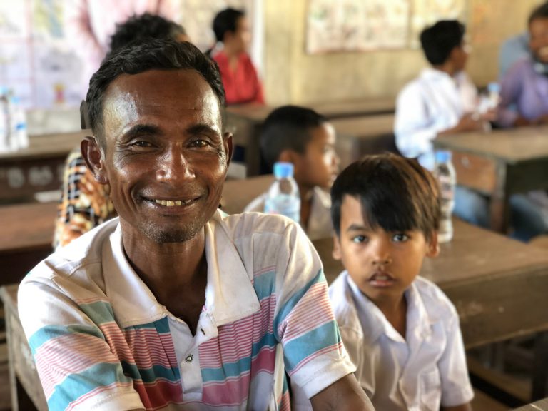 Un padre e un bambino cambogiano aiutati