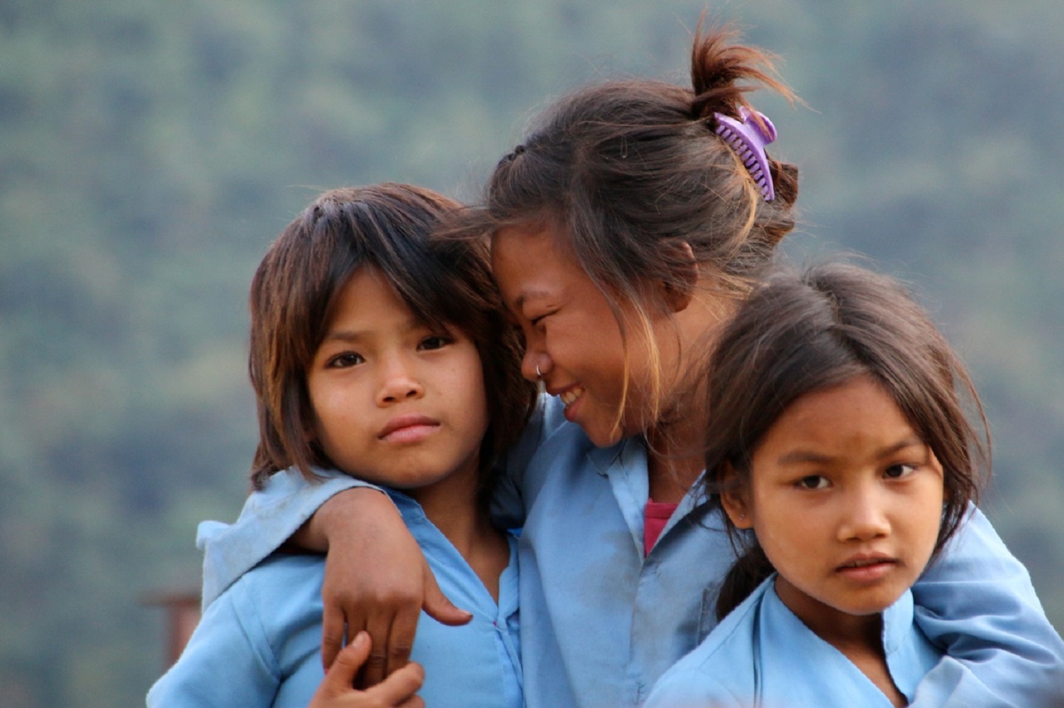 Tre studentesse nepalesi sorridono alla macchina fotografica